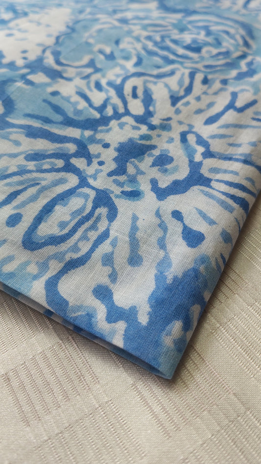Blue and white patterned fabric on a textured beige surface